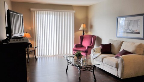 a living room with a couch and a chair and a television